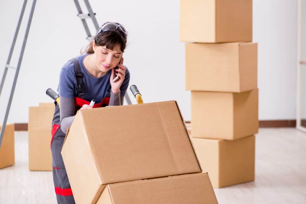 A female contractor labelling boxes in the concept of Man and Van in North London.