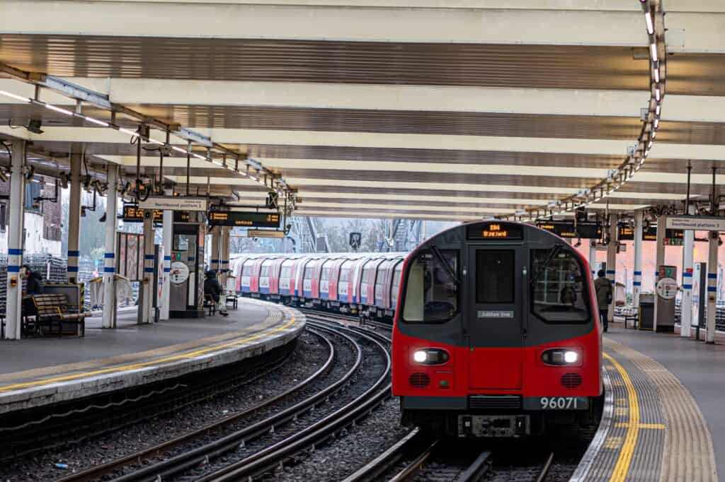 An overground train approaching Finchley Road Station in the concept of services and amenities in North London.