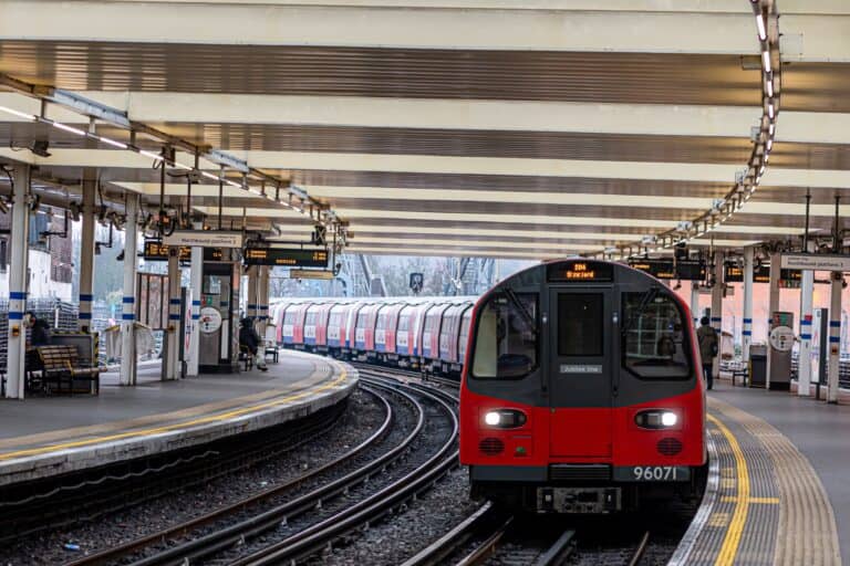 An overground train approaching Finchley Road Station in the concept of services and amenities in North London.