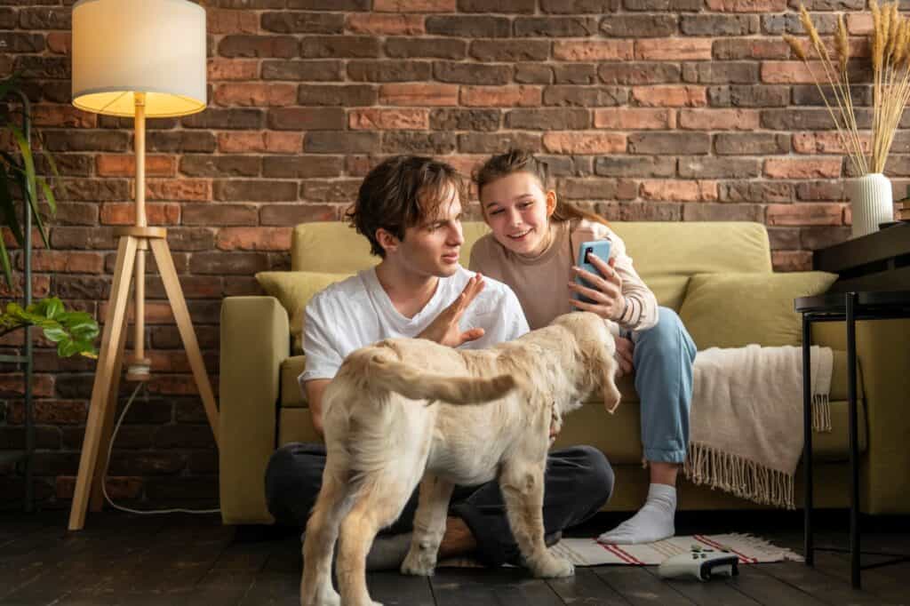 Siblings with their dog during a video call in their new home in the concept of 'managing pet transportation when moving house'.