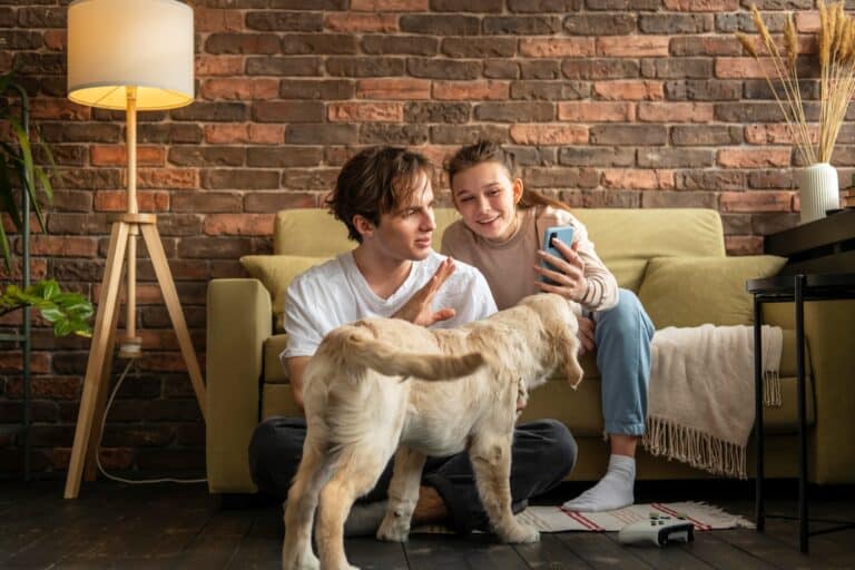 Siblings with their dog during a video call in their new home in the concept of 'managing pet transportation when moving house'.