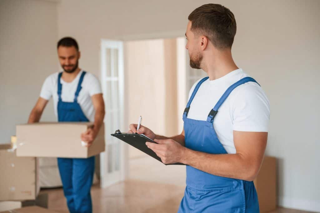 Two Man and Van service crew in a small studio flat on a moving day in the concept of 'can you use a man and van for small moves or single item deliveries'.